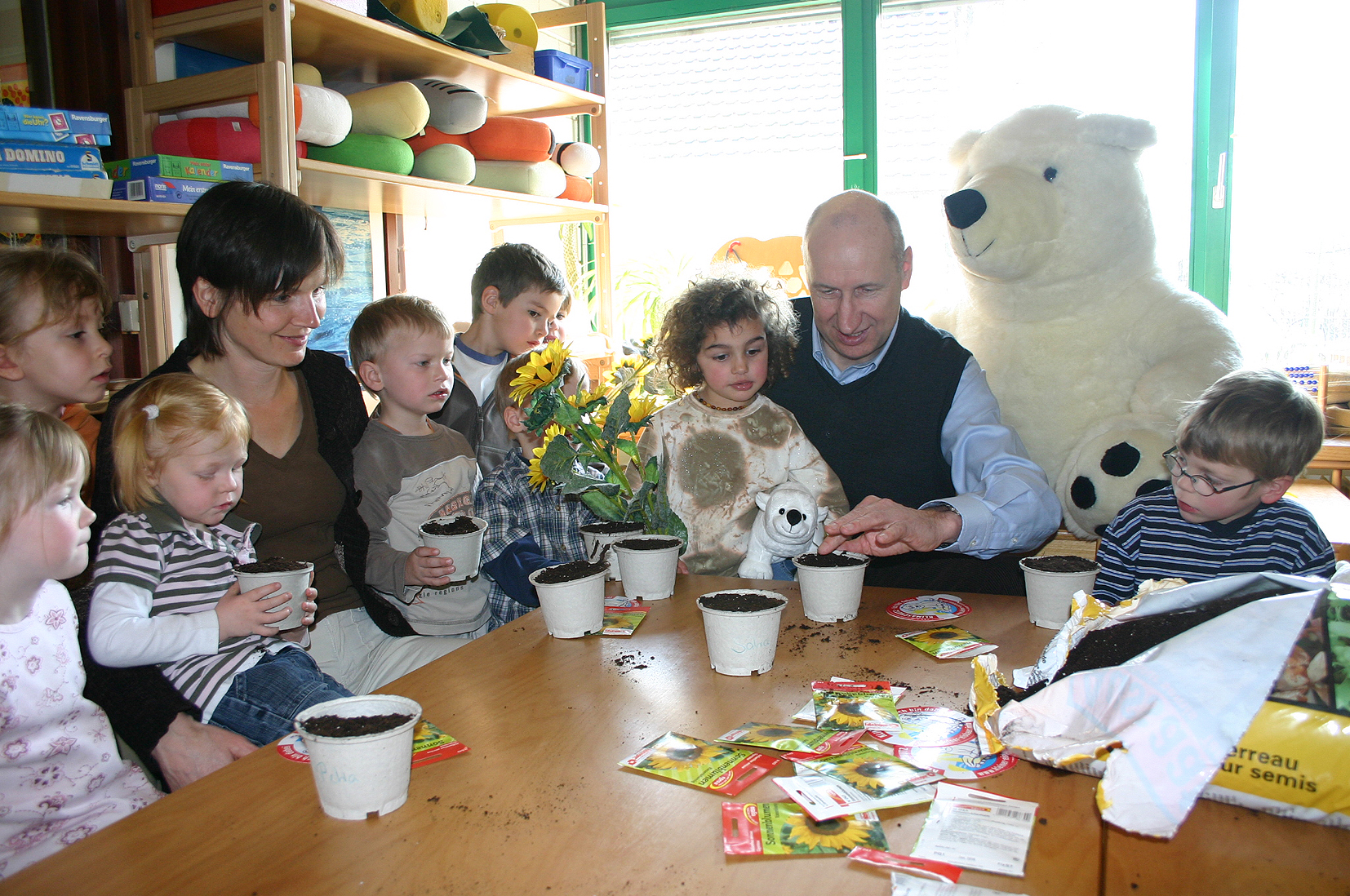 Kinderhände malen mit Buntstiften an einem Tisch